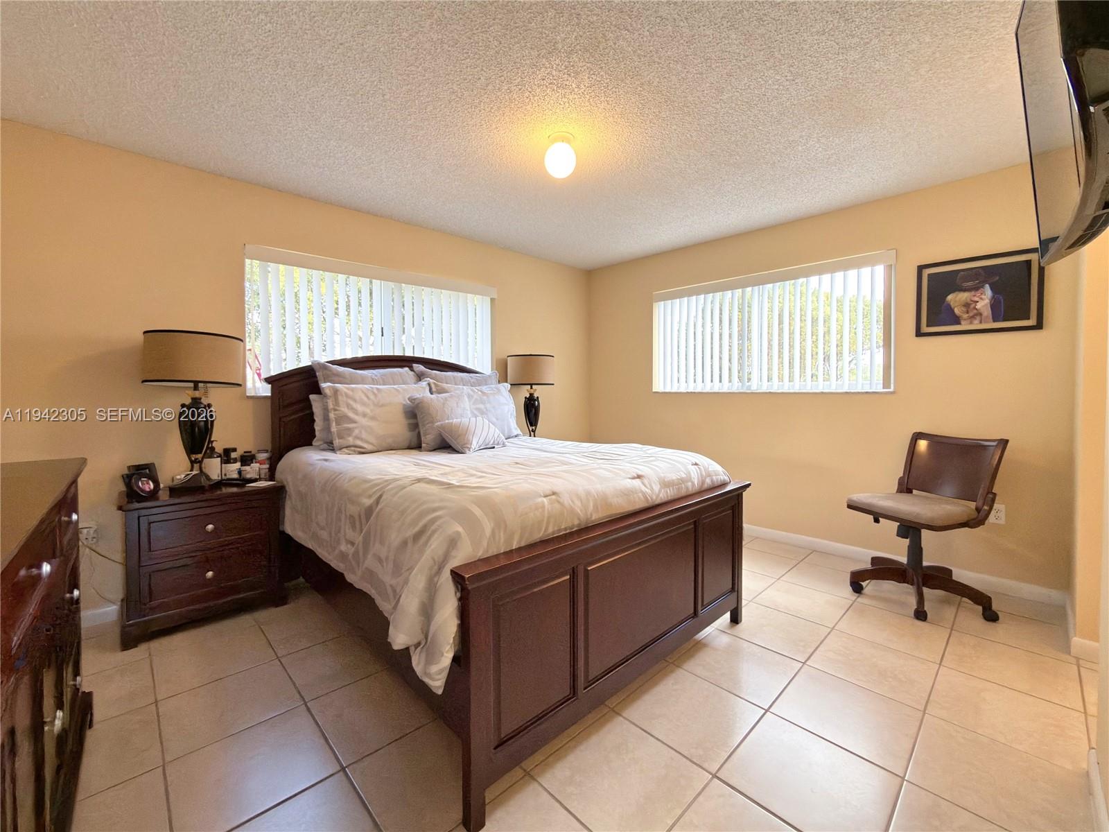 14911 Southwest 80th Street, Unit 221 Miami, FL 33193 - Photo 22 of 31 a bedroom with a bed and wooden floor