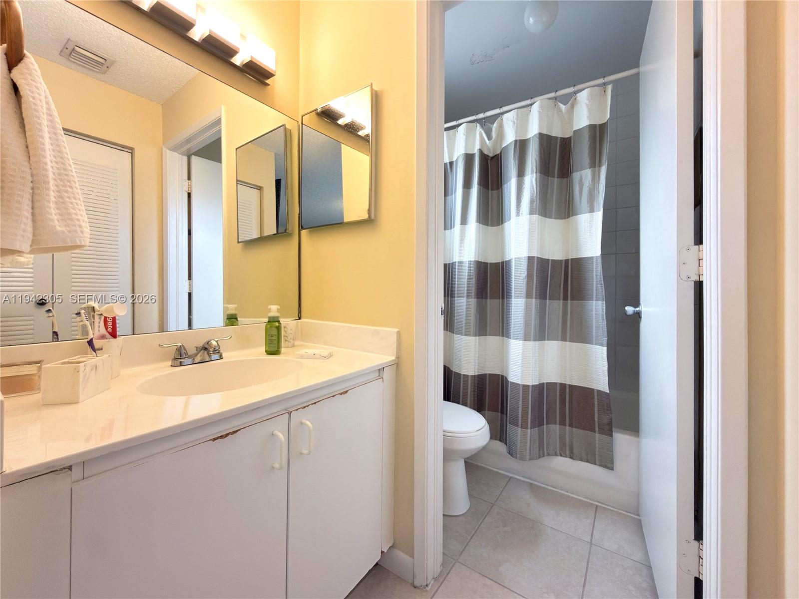14911 Southwest 80th Street, Unit 221 Miami, FL 33193 - Photo 24 of 31 a bathroom with a sink a toilet a mirror and shower