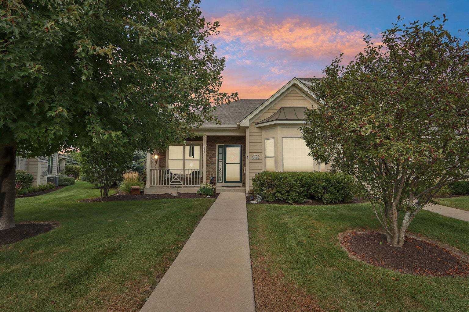 a front view of a house with yard and green space