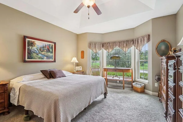 a bedroom with a bed couch and a large window