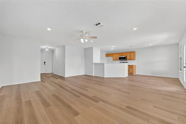 a view of empty room with wooden floor