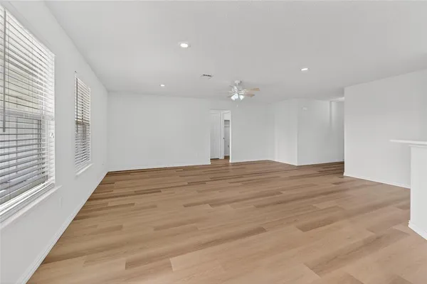 a view of empty room with wooden floor