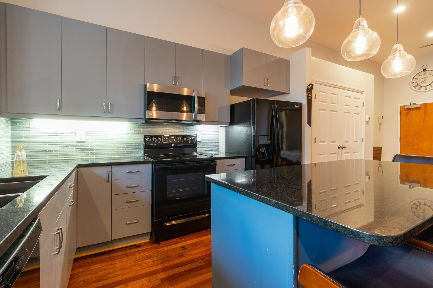323 West Main Street, Unit B Durham, NC 27701 - Photo 5 of 14 a kitchen with stainless steel appliances granite countertop a sink refrigerator stove and microwave