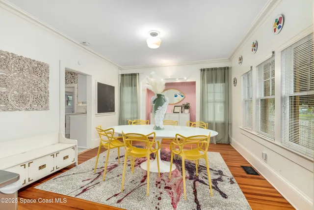 a view of a dining room with furniture a chandelier and wooden floor