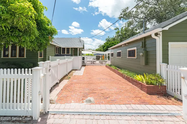 a view of house with yard outdoor seating and covered with trees