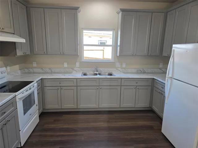 a kitchen with a sink a refrigerator and window