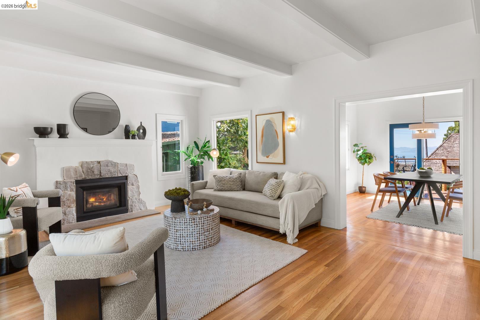 758 Spruce Street Berkeley, CA 94707 - Photo 15 of 60 Living room with light wood-type flooring, a stone fireplace, and beam ceiling