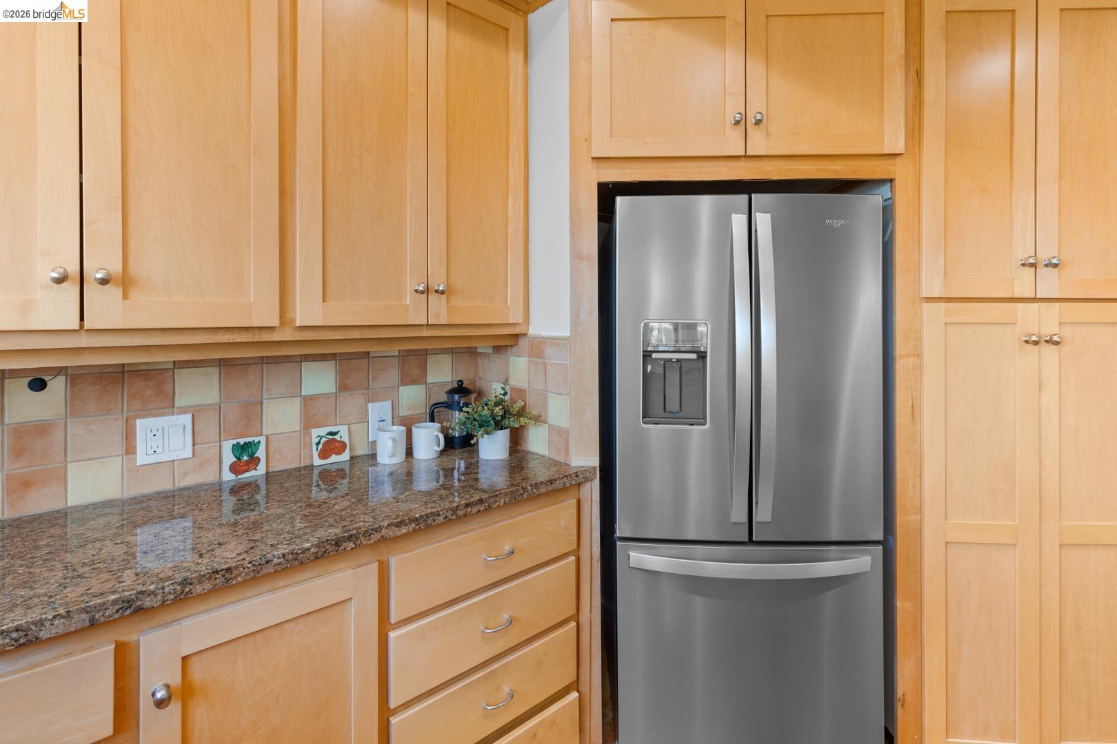758 Spruce Street Berkeley, CA 94707 - Photo 20 of 60 Kitchen with stainless steel fridge with ice dispenser, light wood finish cabinets, and dark stone counters
