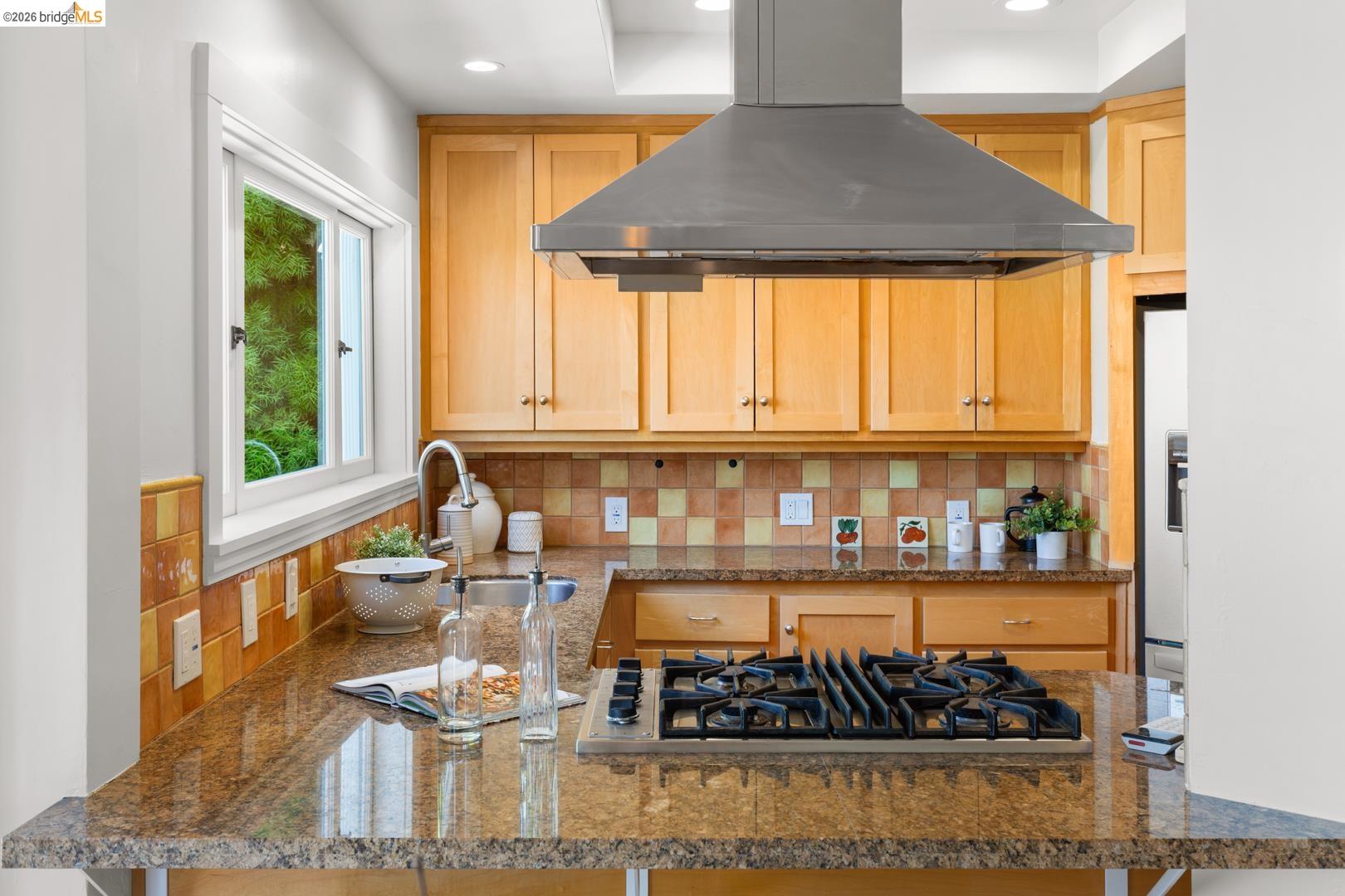 758 Spruce Street Berkeley, CA 94707 - Photo 5 of 60 Kitchen featuring dark stone counters, stainless steel gas cooktop, and light wood finish cabinets
