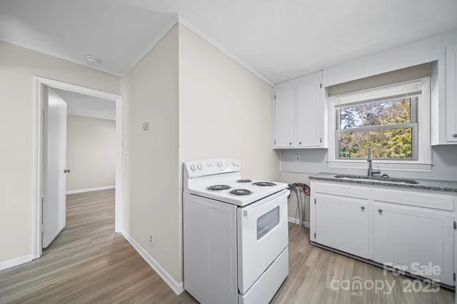 a kitchen with a stove sink and cabinets