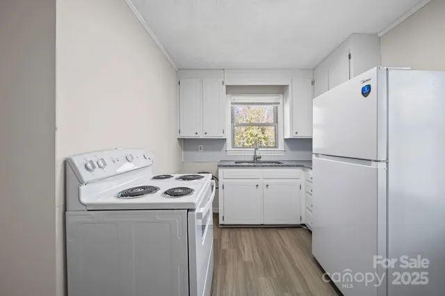 a kitchen with a refrigerator a stove a sink and a window