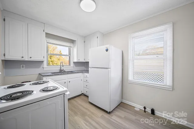 a kitchen with a refrigerator a stove a sink and a window