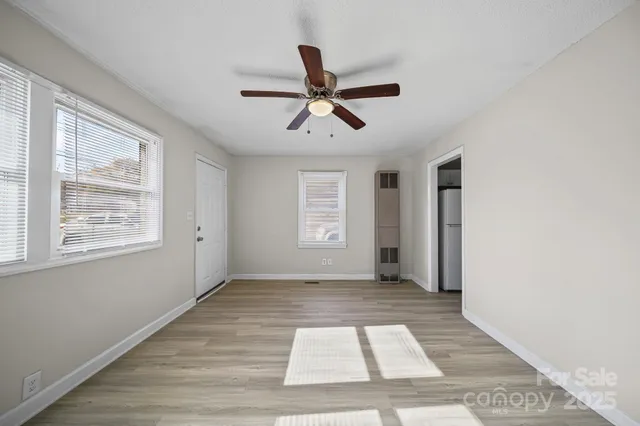 a view of empty room with window and ceiling fan