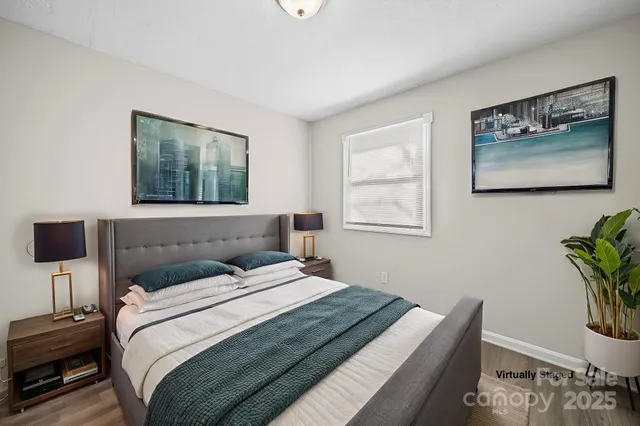 a bedroom with bed and wall painting with wooden floor