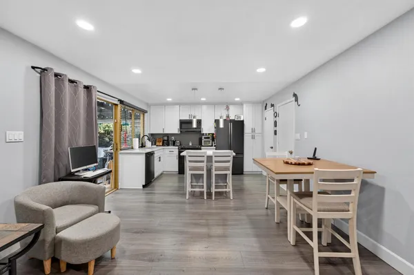 a living room with furniture kitchen view and a chandelier