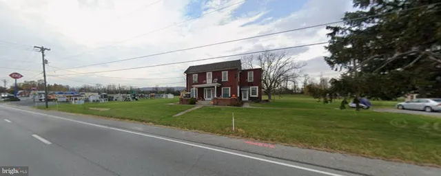 a view of a park that has a car parked on the road