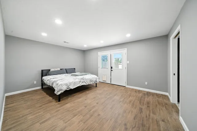 a bedroom with a bed and a wooden floor