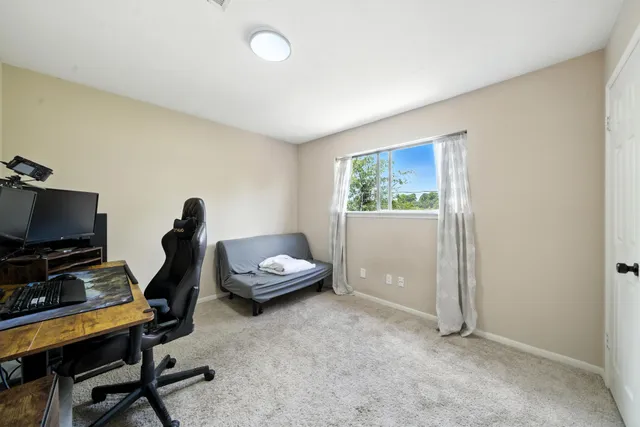 a view of a workspace with furniture and a window