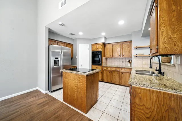 a kitchen with stainless steel appliances granite countertop a sink stove and cabinets