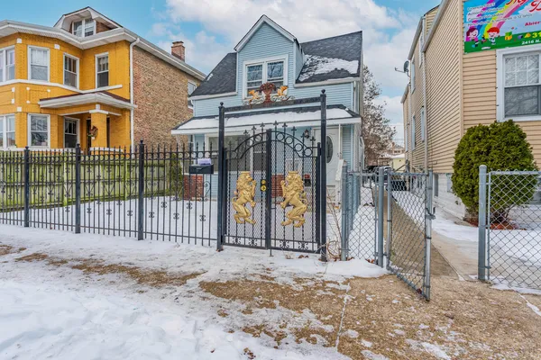 a view of a house with a wooden fence