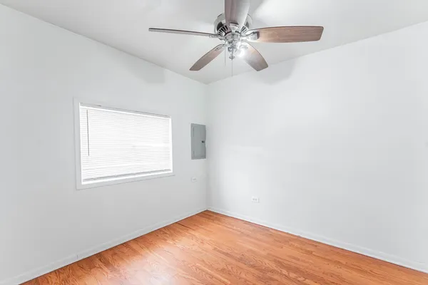 an empty room with a window and a fan
