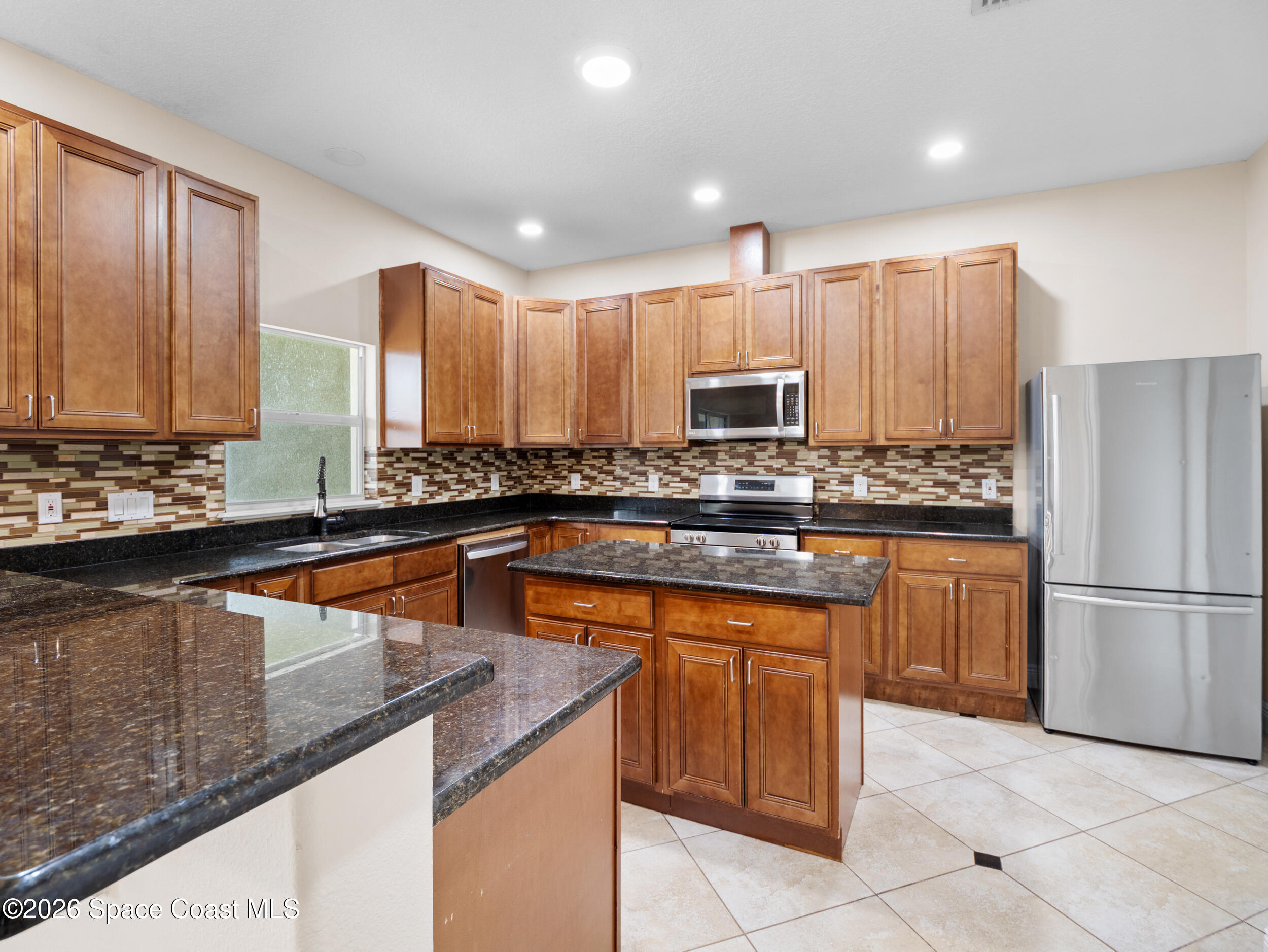 2246 Warwick Road Melbourne, FL 32935 - Photo 11 of 40 a kitchen with stainless steel appliances granite countertop a stove a sink a microwave a refrigerator and cabinets