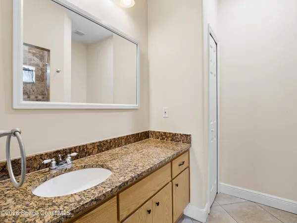 a bathroom with a granite countertop sink and a mirror