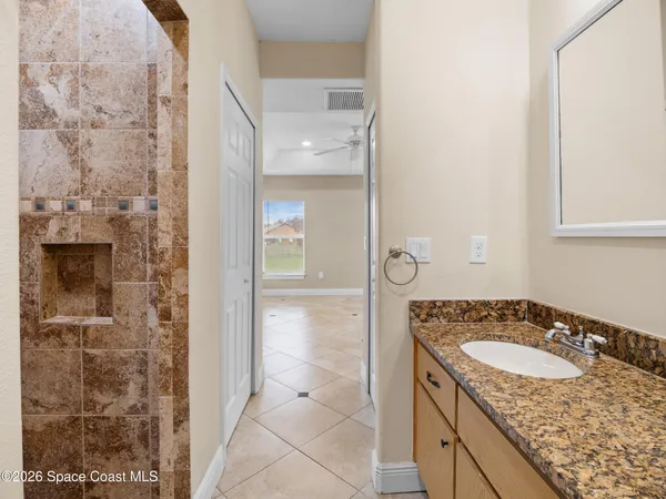 a bathroom with a granite countertop sink a mirror and shower