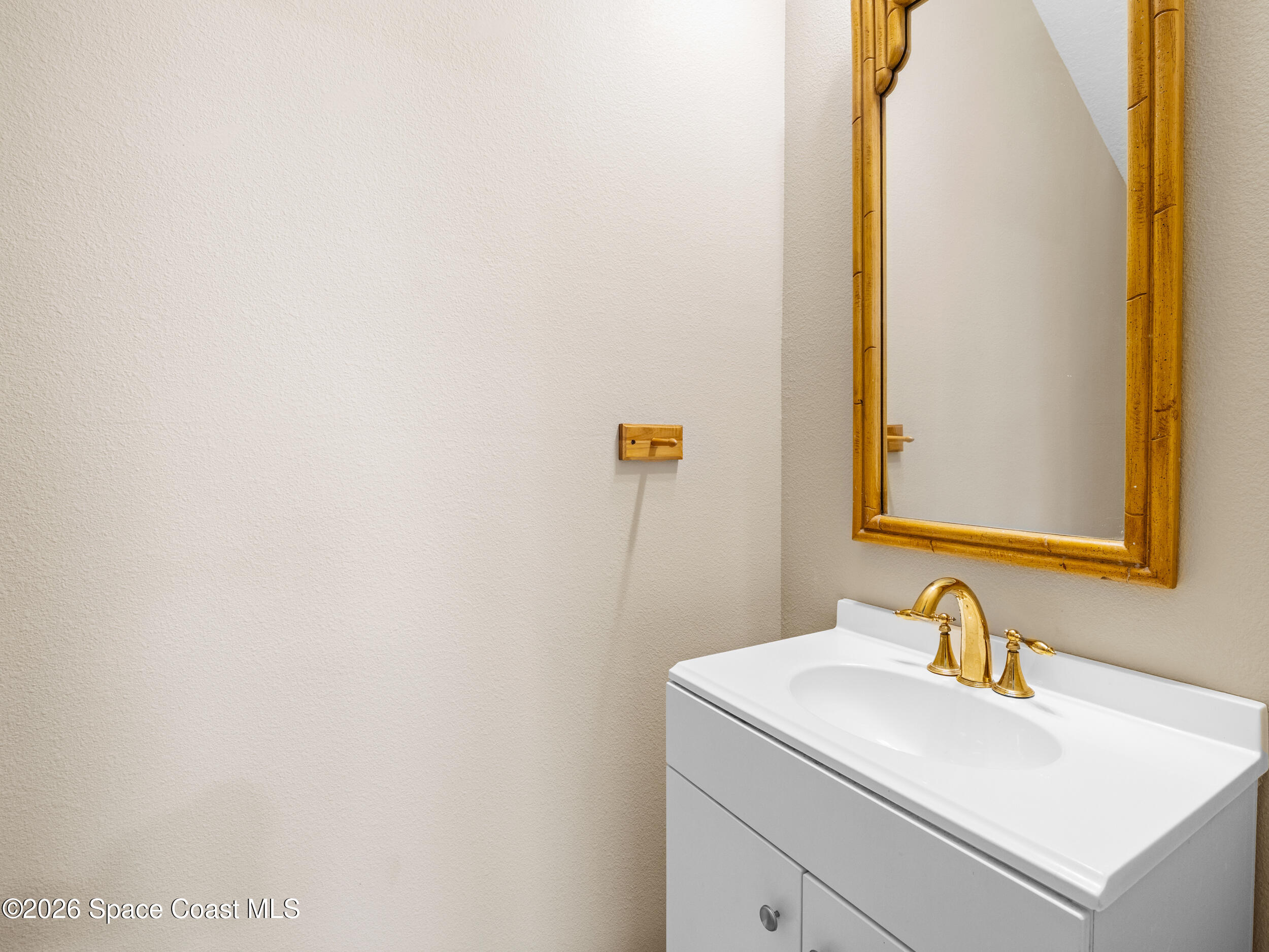 2246 Warwick Road Melbourne, FL 32935 - Photo 17 of 40 a bathroom with a sink and a mirror