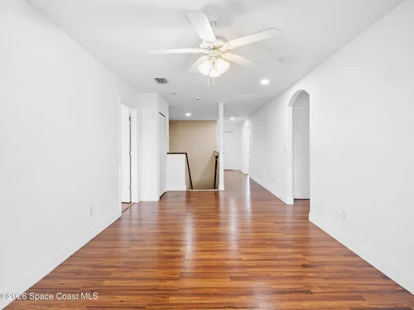 a view of an empty room with wooden floor
