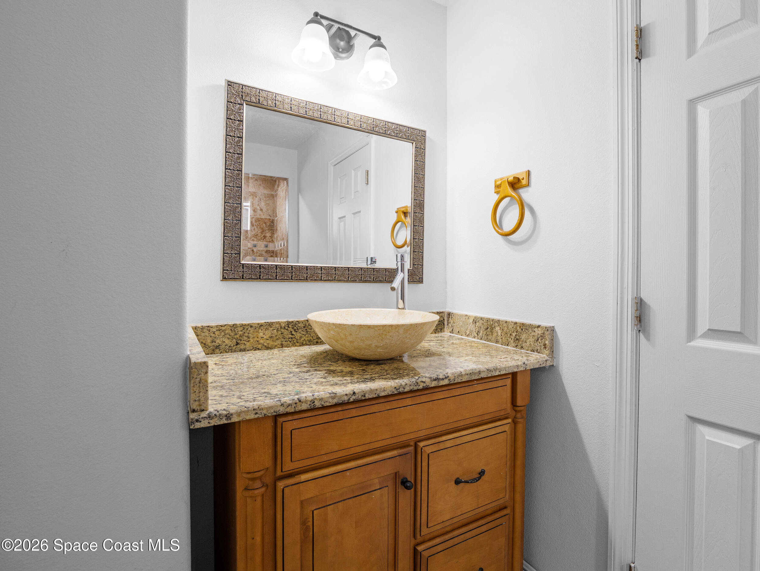 2246 Warwick Road Melbourne, FL 32935 - Photo 22 of 40 a bathroom with a granite countertop sink and a mirror