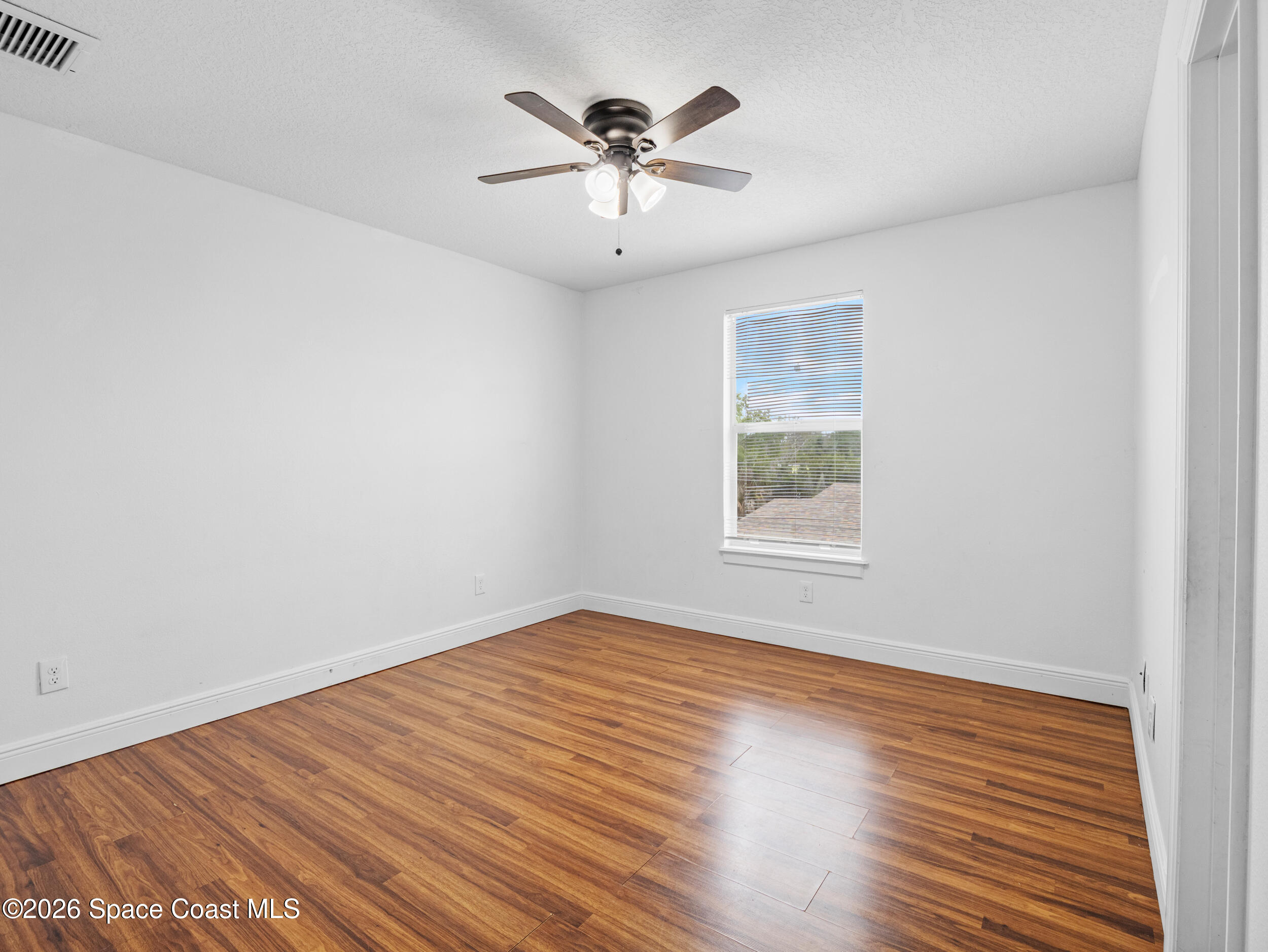 2246 Warwick Road Melbourne, FL 32935 - Photo 23 of 40 an empty room with wooden floor and windows
