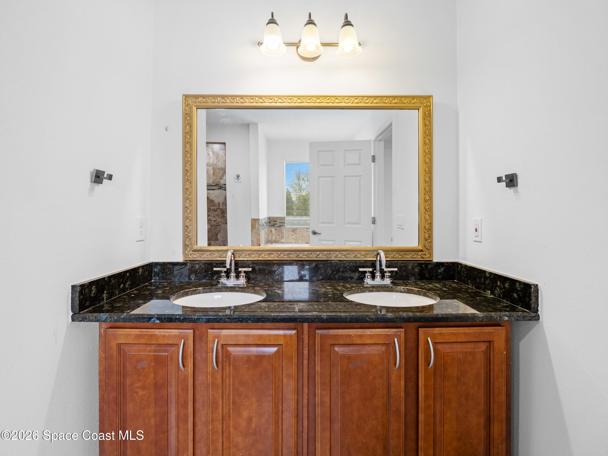 2246 Warwick Road Melbourne, FL 32935 - Photo 26 of 40 a bathroom with a granite countertop sink and a mirror