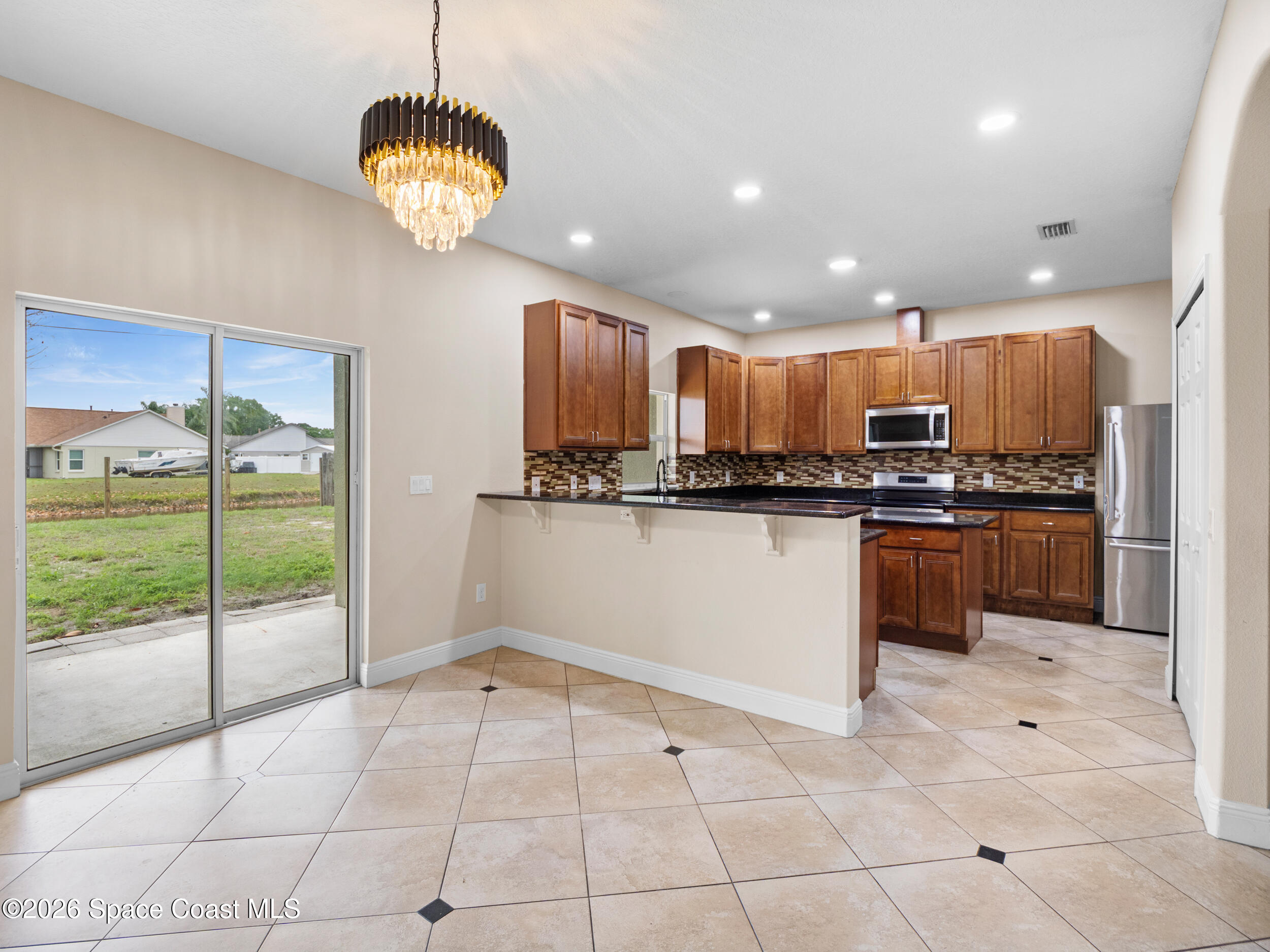 2246 Warwick Road Melbourne, FL 32935 - Photo 8 of 40 a kitchen with stainless steel appliances granite countertop a refrigerator and a sink