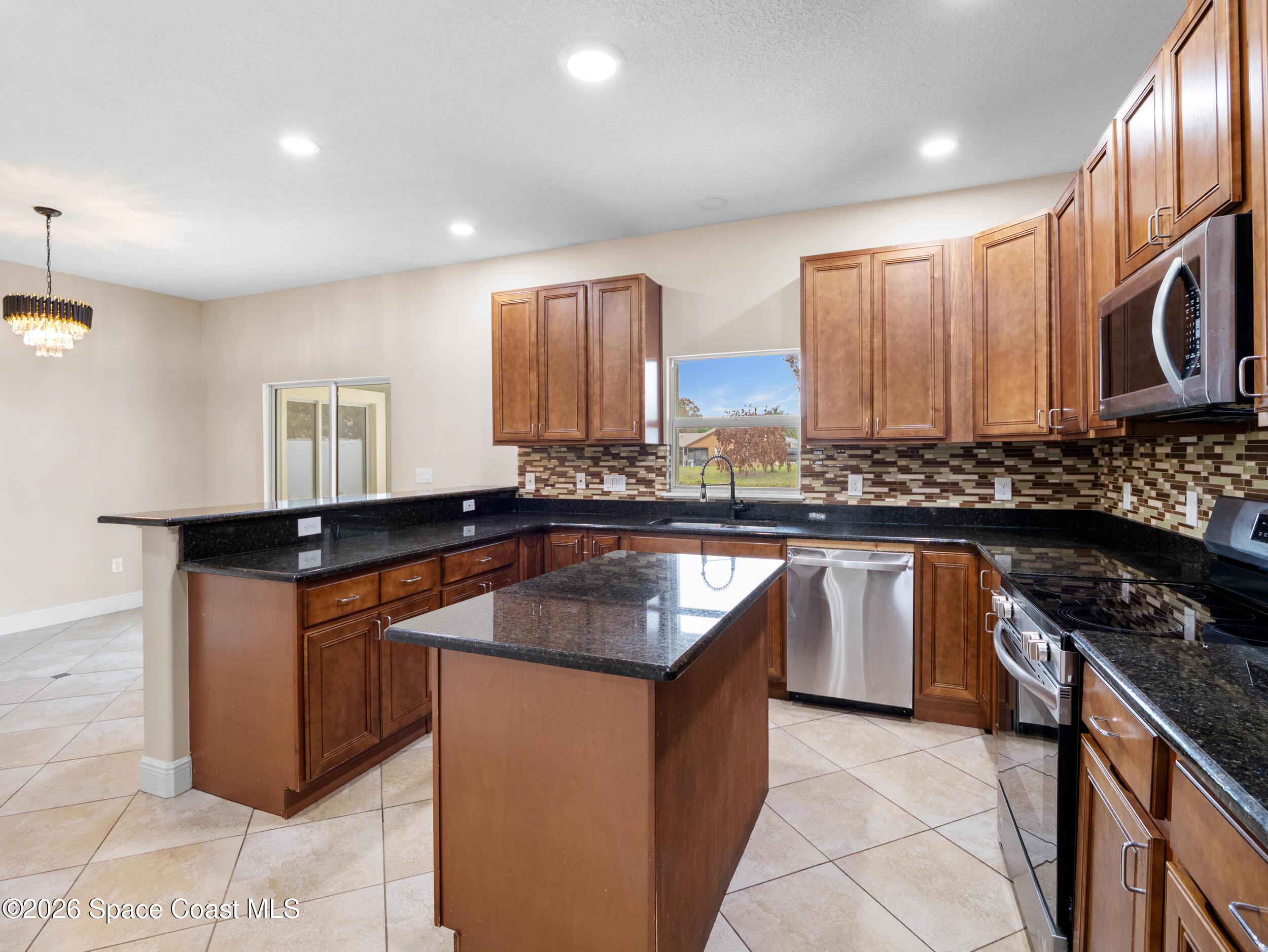 2246 Warwick Road Melbourne, FL 32935 - Photo 10 of 40 a kitchen with stainless steel appliances granite countertop a sink stove and cabinets