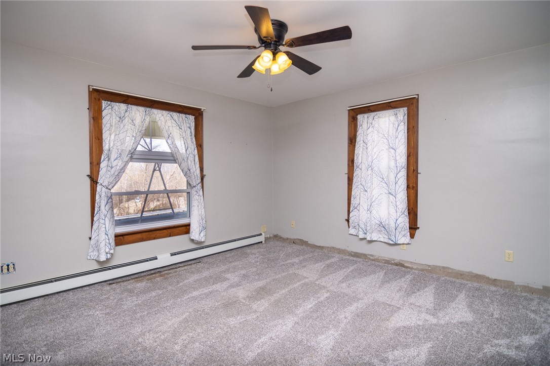 53341 Key Bellaire Road Bellaire, OH 43906 - Photo 14 of 48 Carpeted empty room featuring baseboard heating and ceiling fan