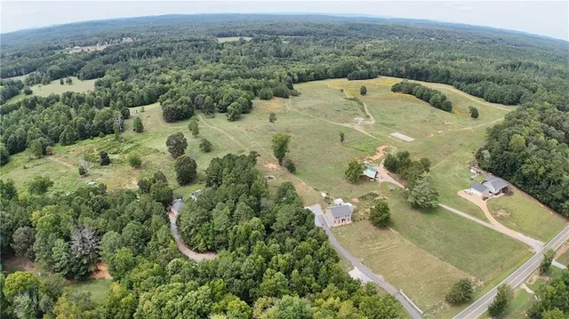 an aerial view of residential houses with outdoor space and trees