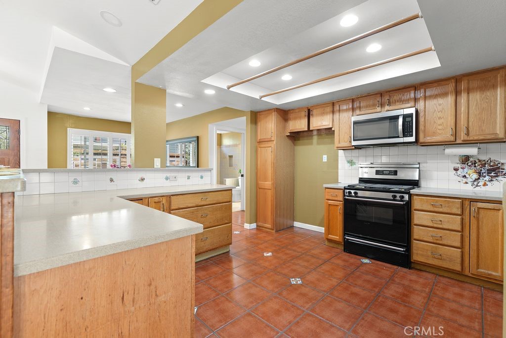 25495 Morningstar Road Lake Forest, CA 92630 - Photo 19 of 31 a kitchen with stainless steel appliances granite countertop a stove a sink and a microwave