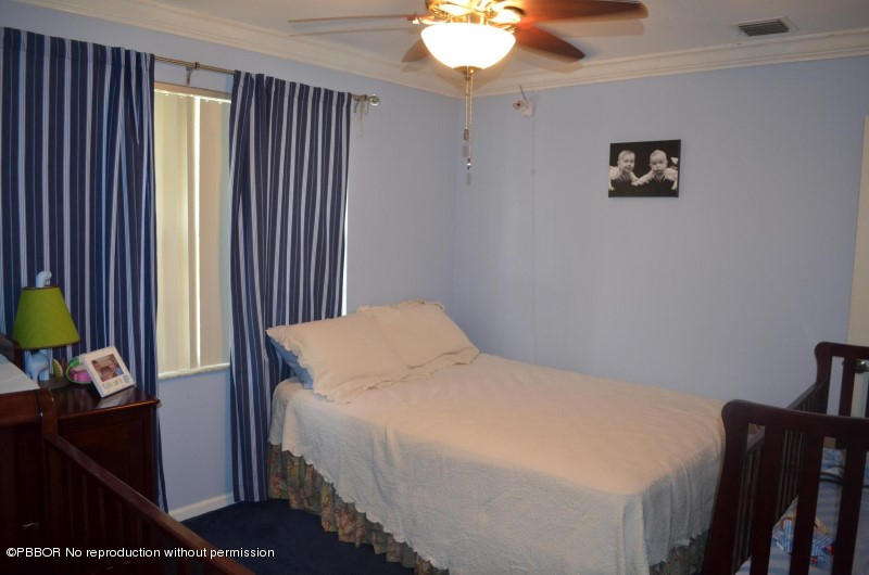 9506 Fox Trot Lane Boca Raton, FL 33496 - Photo 16 of 26 a bedroom with a bed and a lamp on the dresser