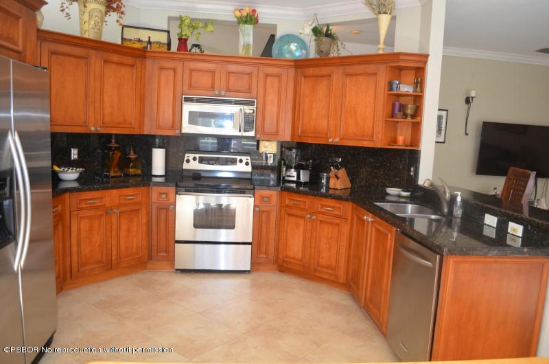 9506 Fox Trot Lane Boca Raton, FL 33496 - Photo 7 of 26 a kitchen with stainless steel appliances granite countertop a stove a sink and a microwave