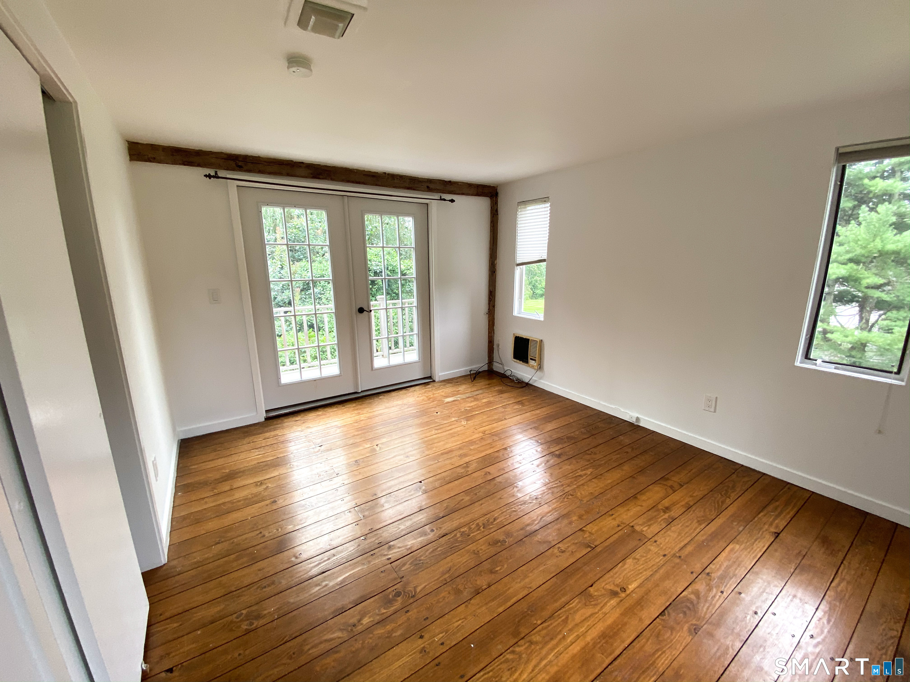 165 Drum Hill Road, Unit A Wilton, CT 06897 - Photo 14 of 24 a view of an empty room with wooden floor and a window