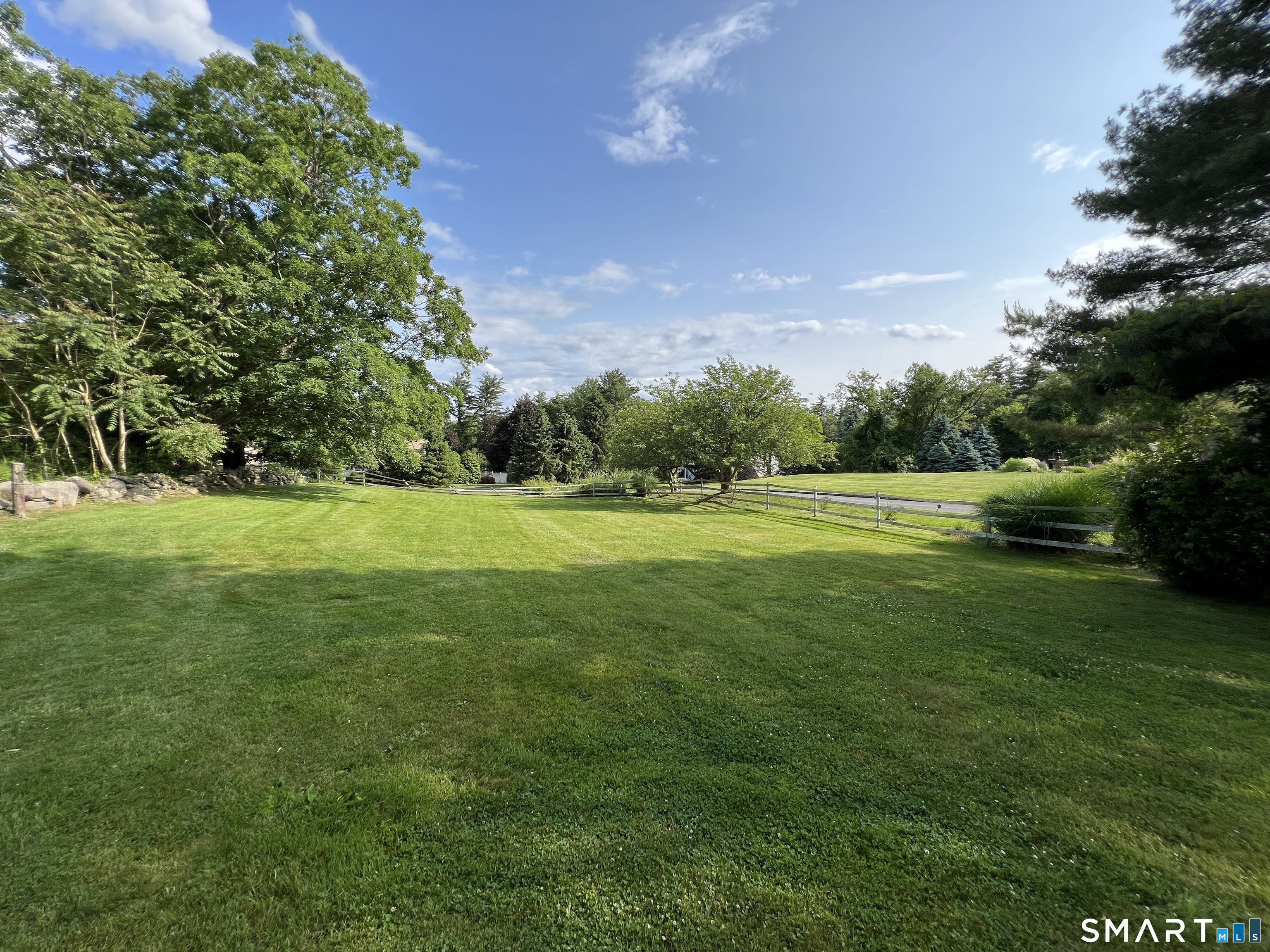 165 Drum Hill Road, Unit A Wilton, CT 06897 - Photo 3 of 24 a view of a grassy field with trees