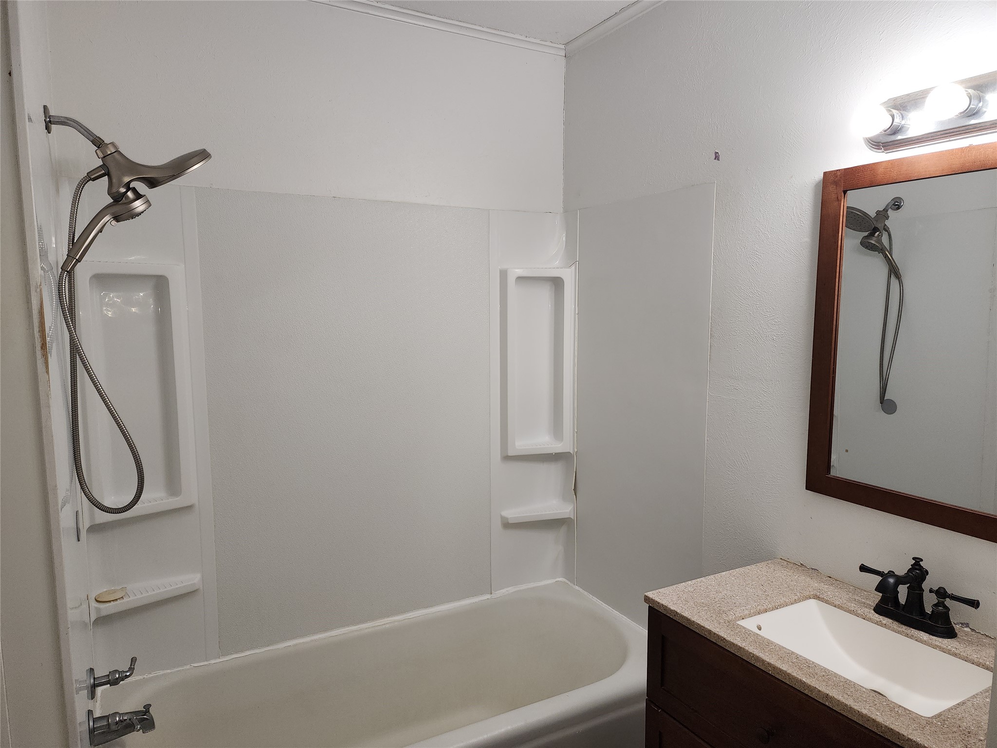 417 Victoria Street Navasota, TX 77868 - Photo 16 of 18 a bathroom with a granite countertop toilet sink and mirror