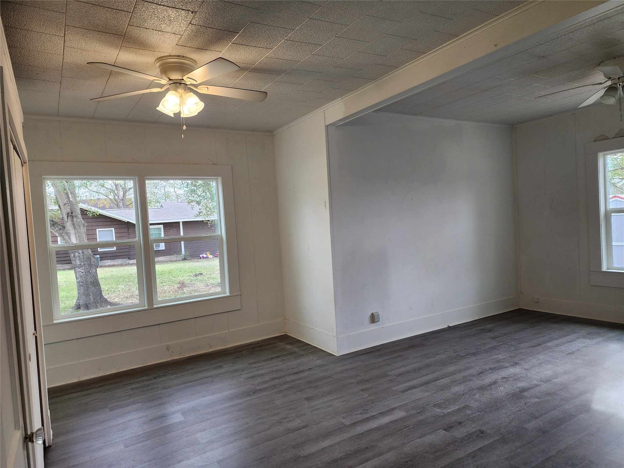 417 Victoria Street Navasota, TX 77868 - Photo 10 of 18 an empty room with wooden floor and windows