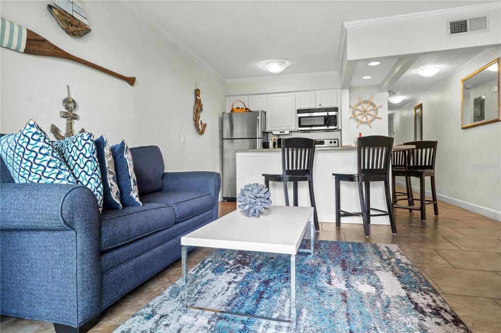 2506 North Rocky Point Drive, Unit 202 Tampa, FL 33607 - Photo 7 of 17 a living room with furniture a flat screen tv and a table