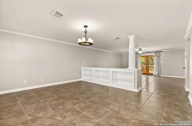 a view of empty room with a kitchen