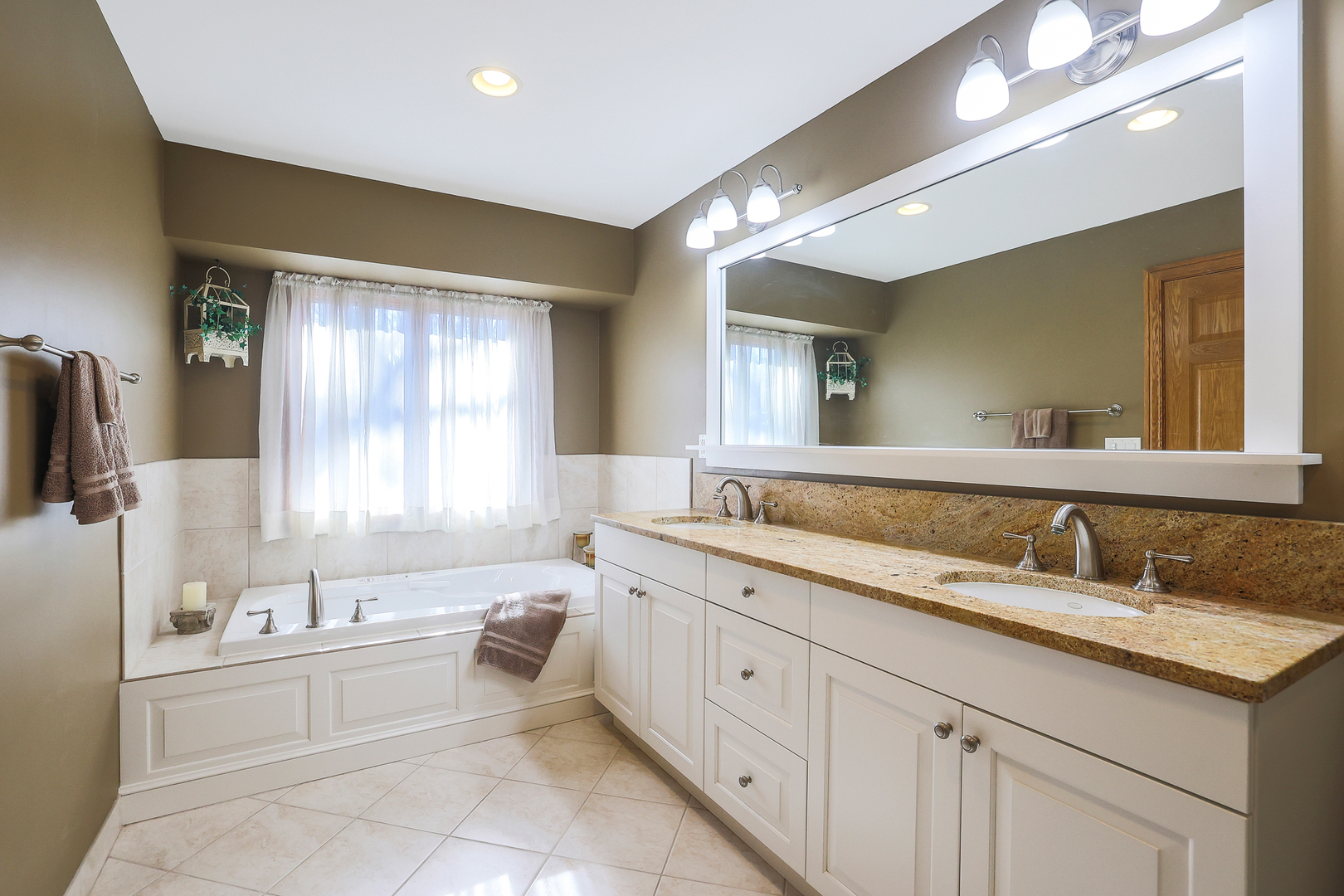 437 High Road Cary, IL 60013 - Photo 19 of 48 a spacious bathroom with a double vanity sink a mirror and a bathtub