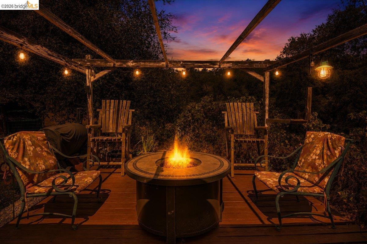 14450 Jacksonville Road Jamestown, CA 95327 - Photo 43 of 85 Wood-finish deck with a pergola structure, strung lighting, and a built-in fire pit