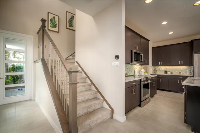 a view of kitchen with stainless steel appliances granite countertop living room and washer
