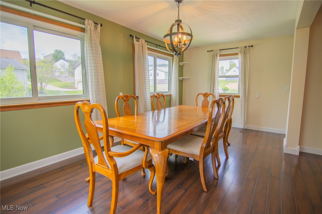 53350 High Ridge Road Bridgeport, OH 43912 - Photo 11 of 37 Dining room featuring baseboards, an inviting chandelier, and dark wood-type flooring